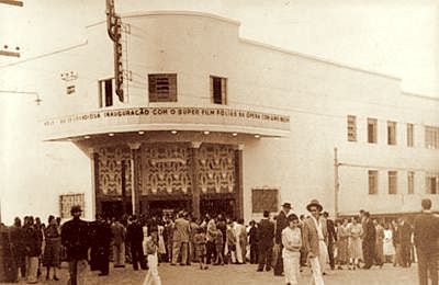Cinema antigo, aglomerado pessoas ao seu redor.